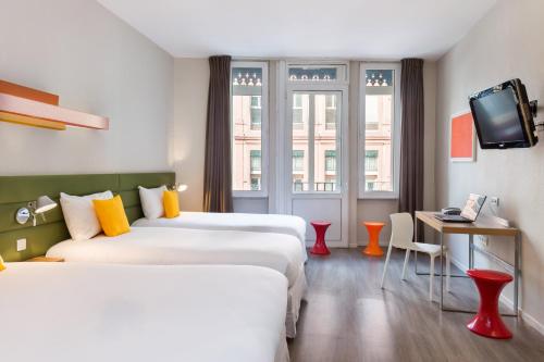 图卢兹Matabi Hotel Toulouse Gare by HappyCulture的一间酒店客房,设有两张床和电视