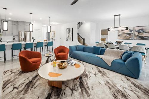 奥兰多Villatel Orlando Resort的客厅配有蓝色的沙发和桌子