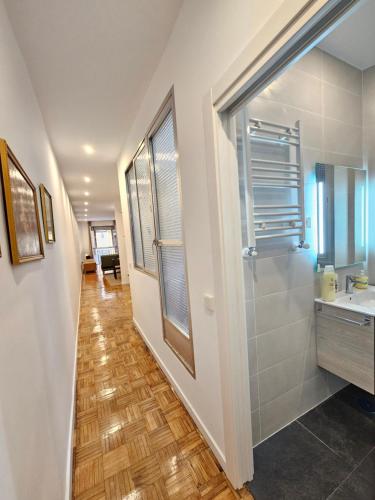 马德里MAD COCO Apartamento Frente al Prado的走廊上设有带水槽和镜子的浴室