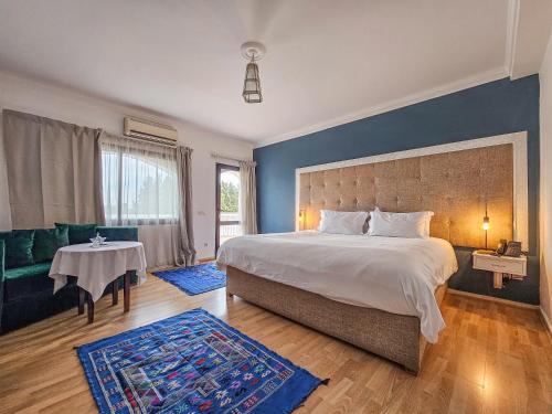 拉巴特Hôtel L'Hacienda的一间卧室设有一张大床和蓝色的墙壁