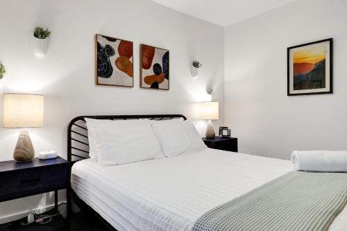圣安东尼奥Artsy - A Birdy Vacation Rental的一间白色卧室,配有两张床和两盏灯。