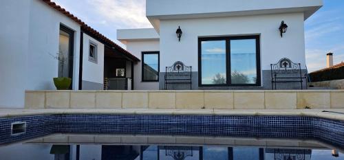 坎普马约尔Casa do Pote的一座白色的房子,前面设有一个游泳池