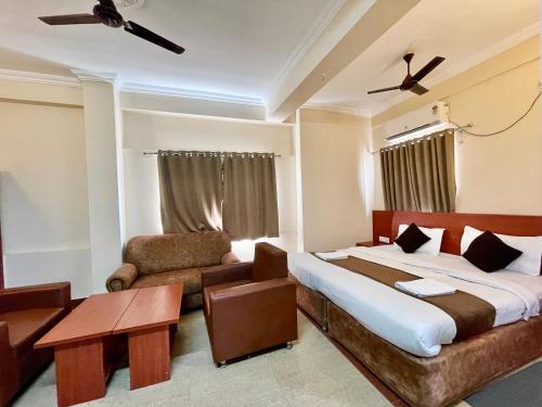 普里Hotel Subham Beach inn ! PURI near-sea-beach-and-temple fully-air-conditioned-hotel with-lift-and-parking-facility的一间卧室配有一张床、一张沙发和一把椅子