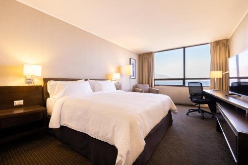 伊基克伊基克智选假日酒店的酒店客房设有一张大床和一张书桌。