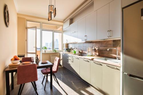 埃里温hotelise l Riverview Apartment的厨房配有白色橱柜和桌椅