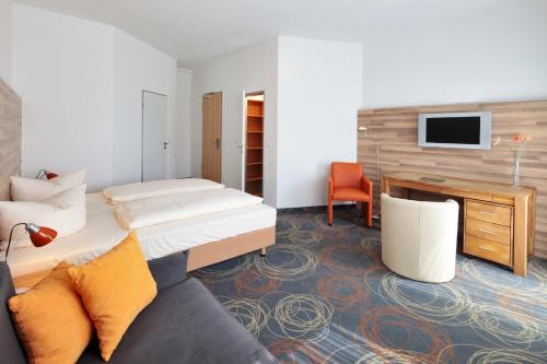 埃森佩杜尔公寓式酒店的酒店客房配有一张床、一张书桌和一张沙发。