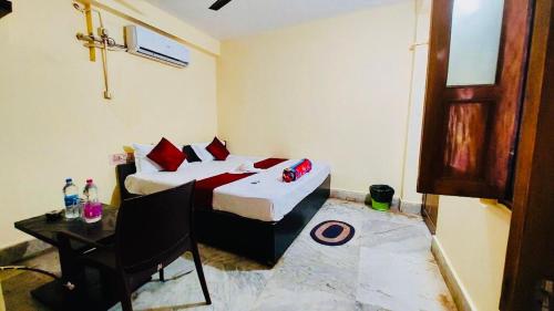 普里Hotel Ashok Royal ! Puri的酒店客房配有一张床铺、一张桌子和一张书桌。