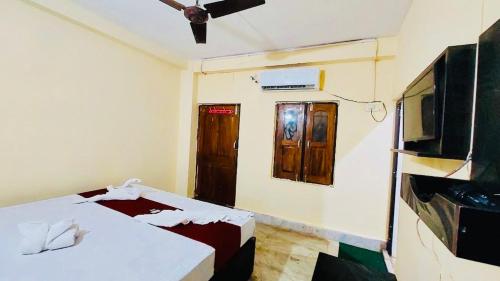 普里Hotel Ashok Royal ! Puri的一间设有两张床、一台电视和一扇门的房间
