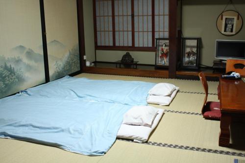 鹤冈市多闻馆酒店的一间卧室配有一张大蓝色的床和两把椅子
