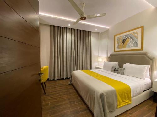 拉合尔Rosewood Lahore的一间卧室配有一张黄色毯子床