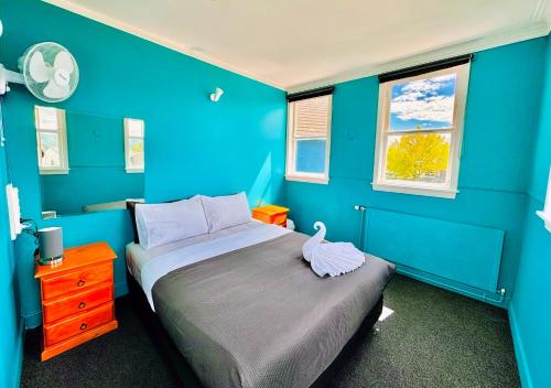 罗托鲁瓦Crashpalace Backpackers的蓝色的卧室,配有床和蓝色的墙壁