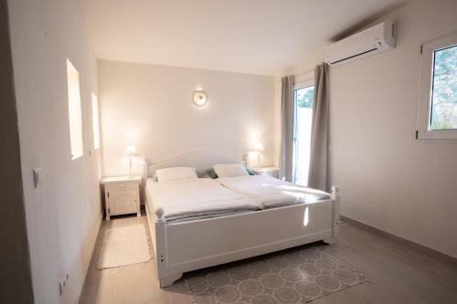 圣何塞Boutique Hotel CASA CARACOL - Apartments in Strandnähe, Salzwasserpool, Fotovoltaik, Adults Only的卧室配有白色的床和窗户。