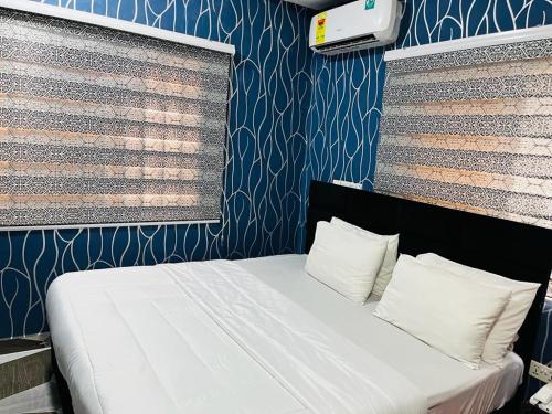 阿克拉Covenant Hotel的卧室配有白色床和蓝色墙壁