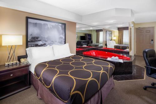 尼亚加拉瀑布Super 8 by Wyndham Niagara Falls by the Falls的酒店客房设有一张大床和一面大镜子