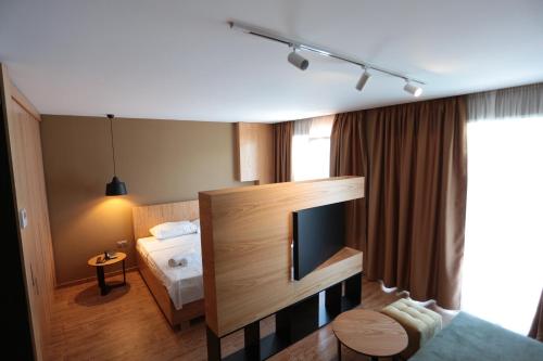 都拉斯Alvin Comfort Hotel的配有一张床和一台平面电视的酒店客房