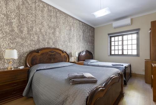 萨布盖鲁Casas do Patrão III Apartamento T2的一间卧室设有两张床和窗户。