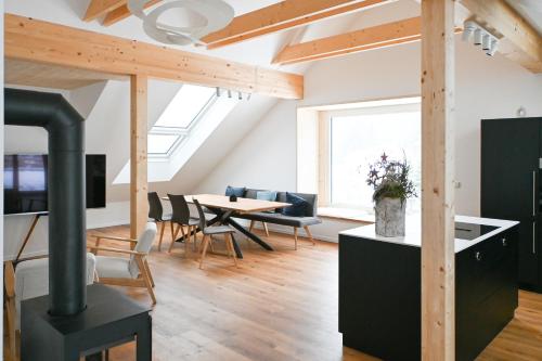拉赫塔尔Arton Lachtal - Apartments Steiermark的厨房和带燃木炉的客厅