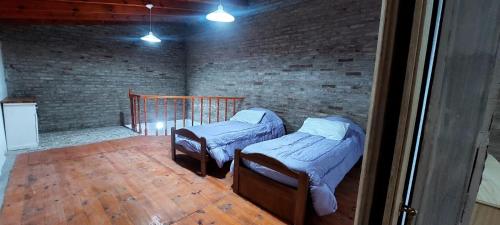 罗萨里奥De leon的砖墙客房的两张床
