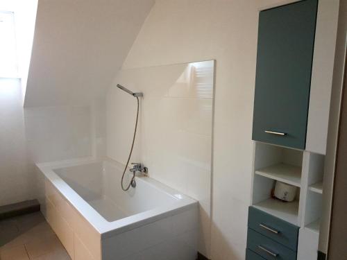 SpengeMonteur-Zimmer Häger的带浴缸和蓝色橱柜的浴室