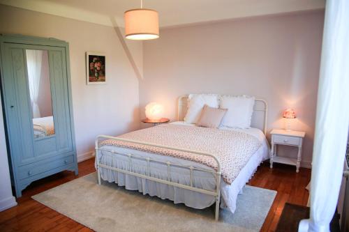 米特尔维Villa Camélias, appartement avec jardin partagé et parking的一间卧室配有一张带两盏灯和镜子的床
