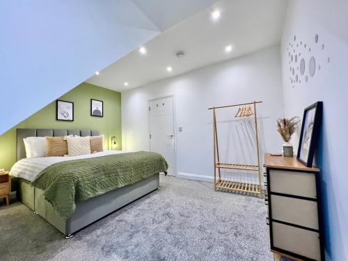 博勒姆伍德2-bed flat in central Borehamwood location的一间卧室设有一张带绿色和白色墙壁的床。