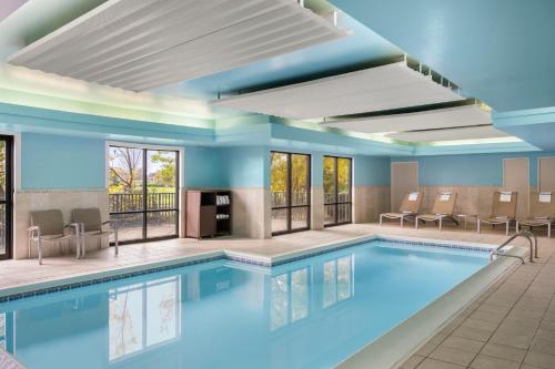 波林布鲁克SpringHill Suites by Marriott Chicago Bolingbrook的游泳池位于酒店带桌椅的客房内