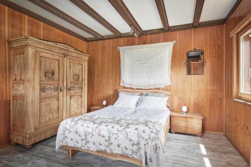 CavagnagoCasa Bubeck的一间卧室设有一张床和木墙