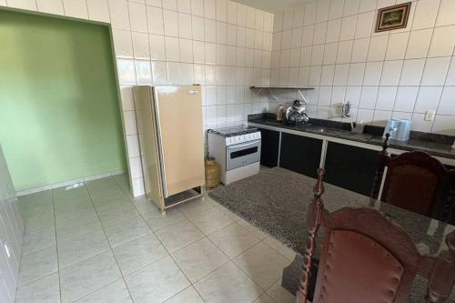瓜拉派瑞Apartamento em Setiba的厨房配有冰箱和炉灶。