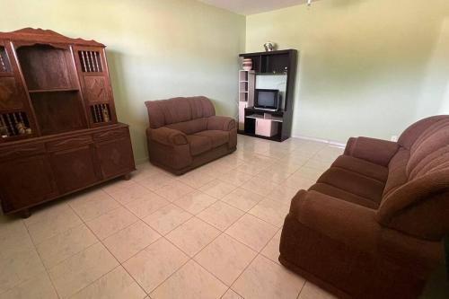 瓜拉派瑞Apartamento em Setiba的客厅配有沙发和椅子