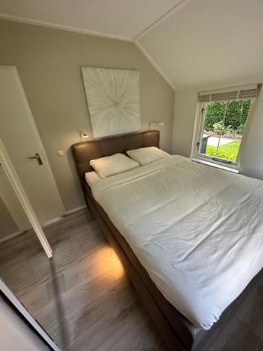 皮滕Bungalow Veluws Vertoeven的一间卧室设有一张大床和窗户