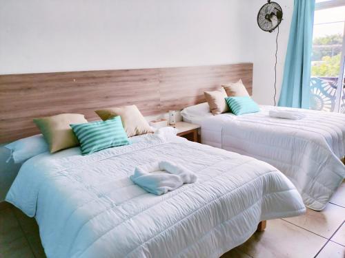 瓦哈卡市Aqua Suites的客房内的两张床和毛巾