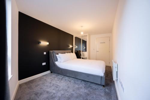 南安普敦Luxury Apartment by Ocean Village Marina的一间卧室设有一张大床和黑色的墙壁