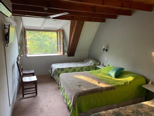 贝尔格拉诺将军镇HOTELPRATERVGB的一间卧室设有两张床、一个窗口和椅子