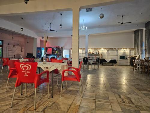 缅济热奇Archimedes Tourist Sp. z o.o.的一间用餐室,配有红色的椅子和桌子