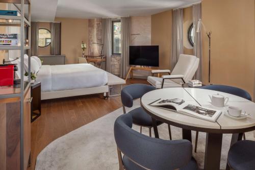 纽约NH Collection New York Madison Avenue的酒店客房带一张床、一张桌子和椅子