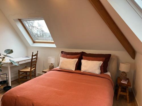 阿姆斯特丹Inn Het Nest的一间卧室配有一张橙色床、书桌和窗户。