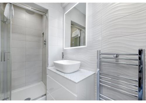 伦敦Lovely 4 bedroom with Outdoor space!的白色的浴室设有水槽和淋浴。