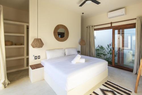 埃斯孔迪多港La petite Casa - Luxury home close to La Punta的卧室设有白色的床和大窗户