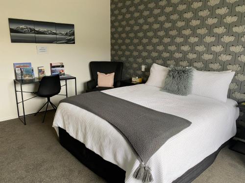 克伦威尔Lakeview Terrace Accommodation的一间卧室配有一张大床和一把椅子