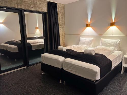 霍芬瑟尔杰维利酒店的配有一张大床和镜子的酒店客房