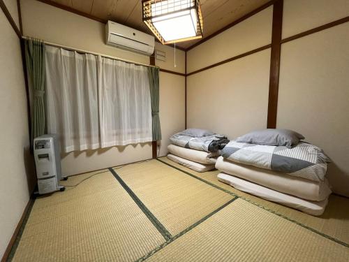 旭川Nagayama Home的带窗户的客房内的两张床