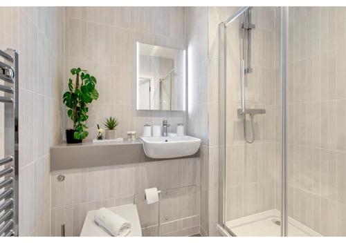 贝肯翰姆Sophisticated Living: 1-BR Flat in Beckenham的白色的浴室设有水槽和淋浴。