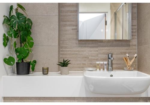 贝肯翰姆Cosmopolitan Living: Upscale 1BR Gem in Beckenham的浴室设有白色水槽和镜子
