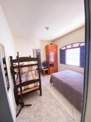 蒙加瓜Casa em Mongaguá Plataforma的一间卧室设有一张床和一个窗口
