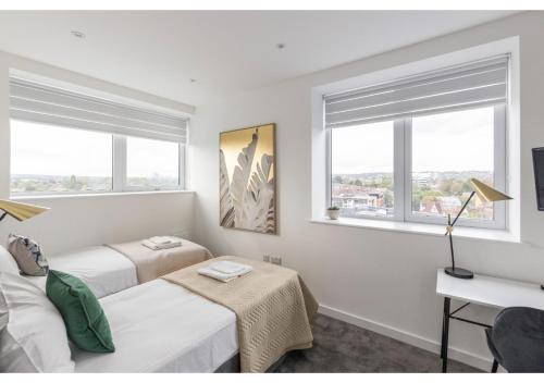 贝肯翰姆Designer Flat in Prime Location的一间卧室设有两张床和两个窗户。