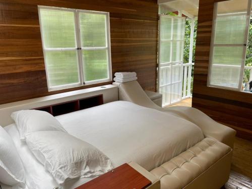 圣弗朗西斯科Villas del Rio Glamping的卧室配有白色的床和2扇窗户。