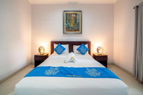 库塔库塔雅旅馆的一间卧室配有蓝色和白色床单
