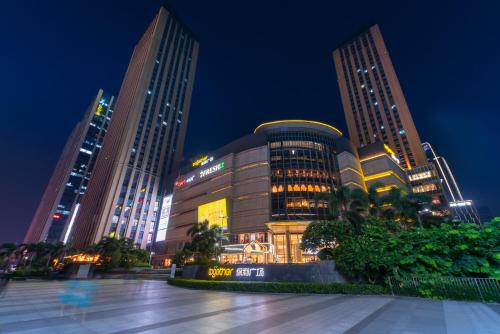 广州广州丽途国际公寓酒店（琶洲会展中心店）的一群高大的建筑在晚上在城市里