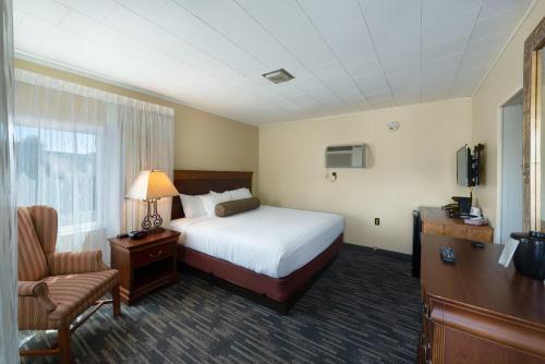 乔治湖斯科蒂湖滨度假酒店的配有一张床和一把椅子的酒店客房
