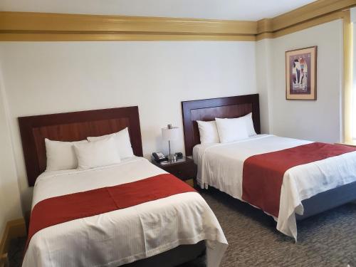 旧金山Relaxing Stay at Executive Hotel San Francisco的酒店客房带两张红色和白色的床单